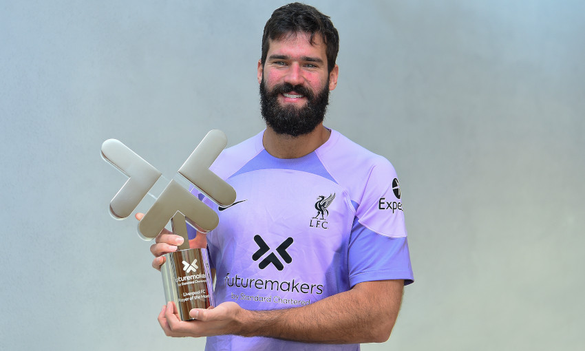 Alisson Becker poses for a photo with the Standard Chartered Men's Player of the Month award for October 2022