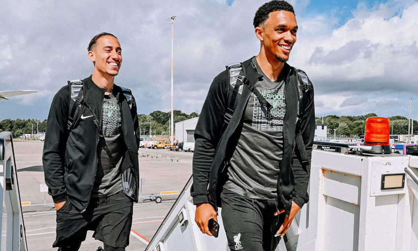 Kostas Tsimikas and Trent Alexander-Arnold smile as they depart for Liverpool's pre-season training camp in Germany